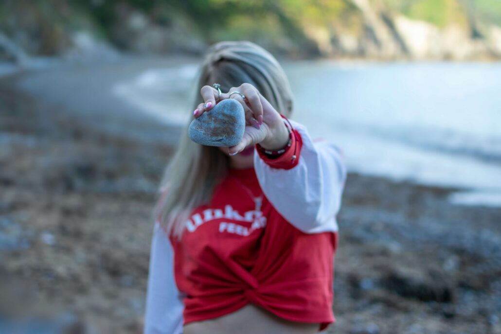 Girl with heart rock on beach