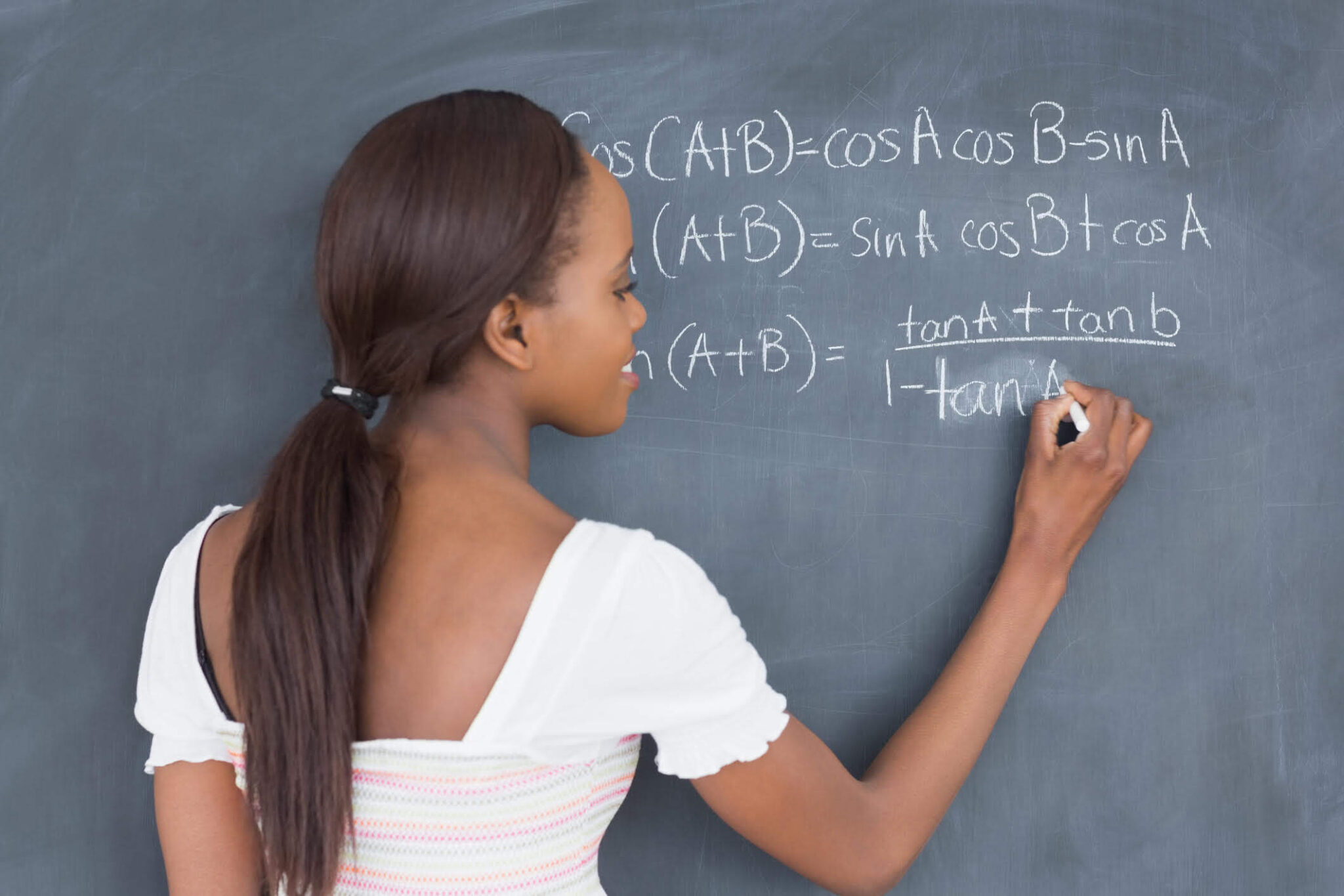 Smart girl writing on blackboard